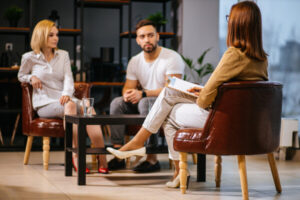 Man and woman sitting with a lawyer through a divorce mediation hearing