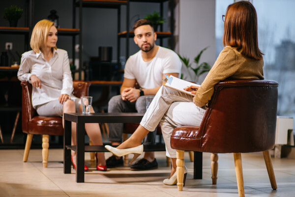 Man and woman sitting with a lawyer through a divorce mediation hearing