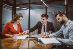 man and woman with lawyer going over property division