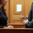 A woman and her attorney speaking privately in a quiet, professional atmosphere.