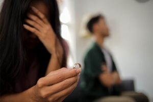 Wife's hand holding wedding ring in disappointment and upset her husband, which may lead to divorce.