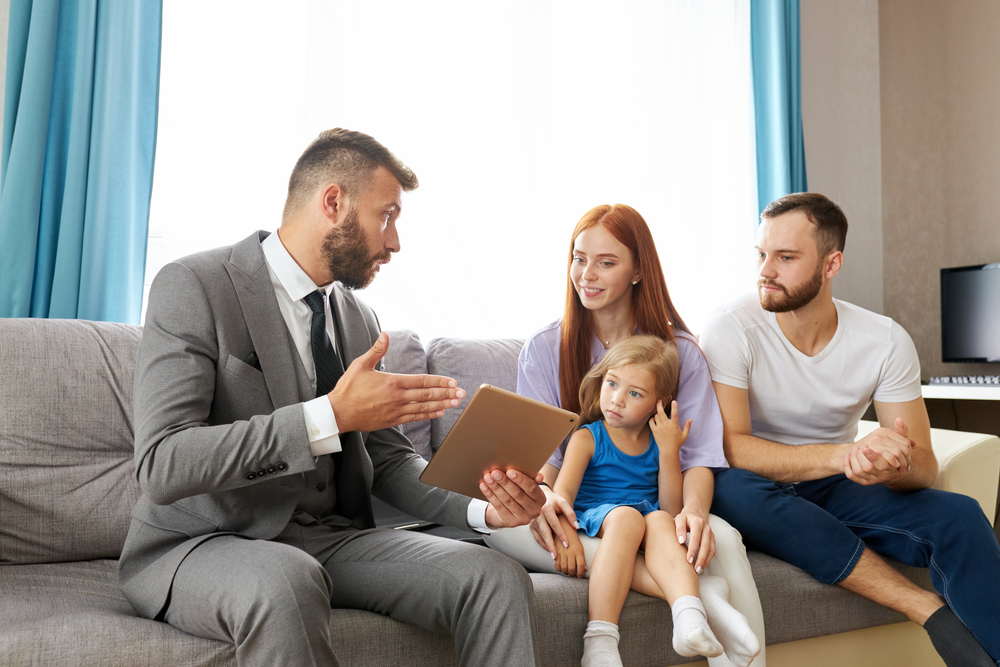 friendly caucasian male psychologist help family going to be divorced, try to eliminate potential psychological problems of child girl, psychologist talk something, showing tablet.