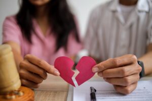 Hands of Wife and Husband Holding Broken Heart Pieces. Concept of Divorce and Legal Separation.