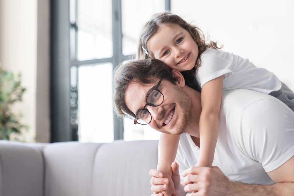 Loving cheerful young father with his small kid daughter girl having fun together, spending time, celebrating father`s day.