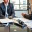 a 16-year-old teen sits across from a professional family lawyer in a modern Utah law office. Papers and legal forms are on the desk.