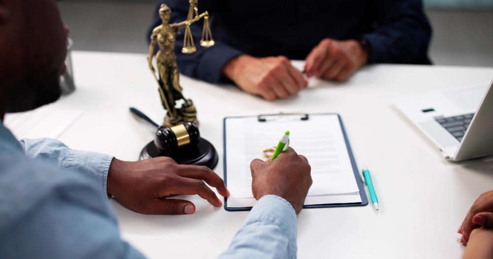 African-American Man And Hispanic Woman Consult Divorce Lawyer In Court.