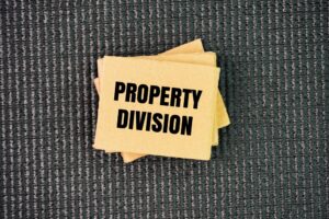 Paper with the word property division. the legal process of dividing assets and debts acquired during the marriage.