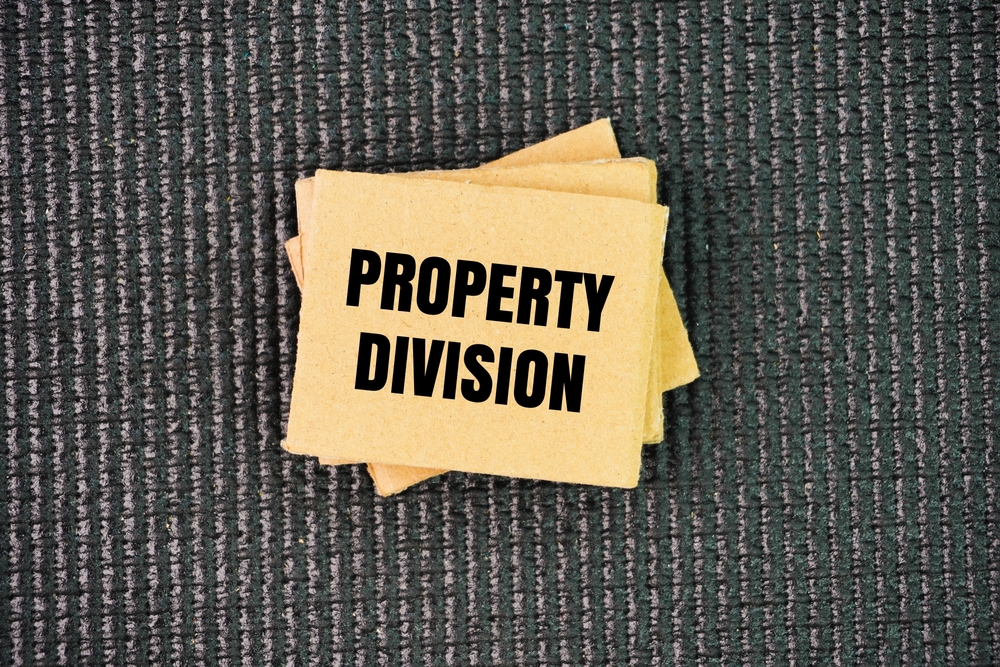 Paper with the word property division. the legal process of dividing assets and debts acquired during the marriage.