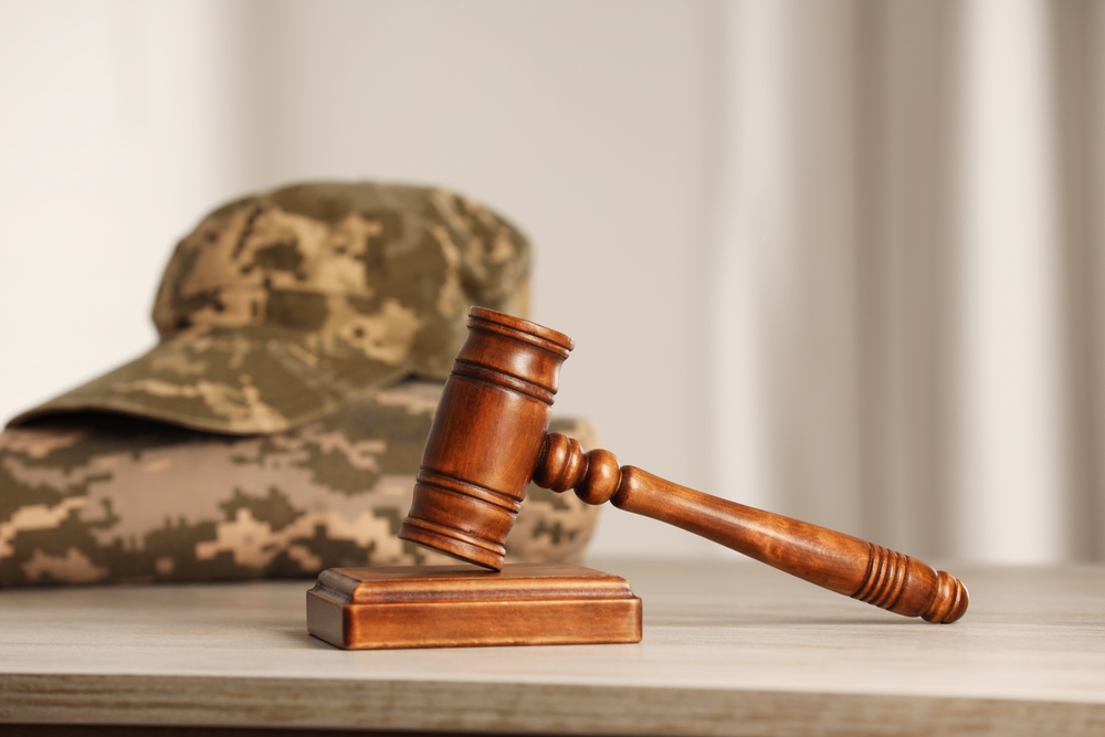Law concept. Gavel and military uniform on wooden table