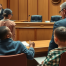 A courtroom scene in Utah, showing a concerned parent sitting across from a judge.