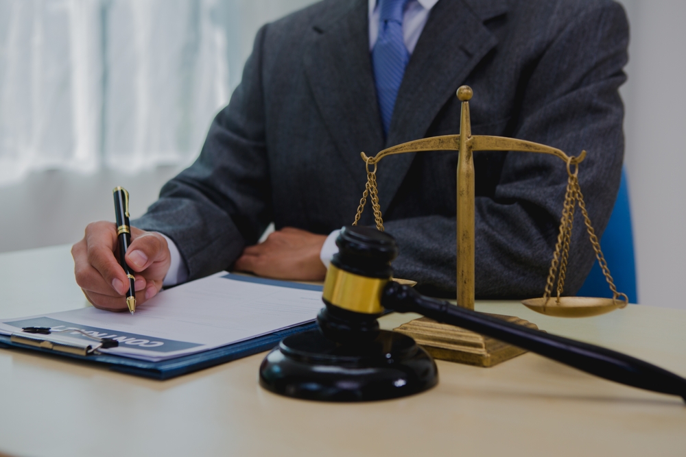 A dark-skinned Asian lawyer, dressed in professional attireon. provide legal advice, preparing cases in law office.