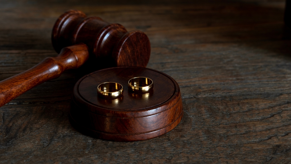gavel and wedding rings on wooden table