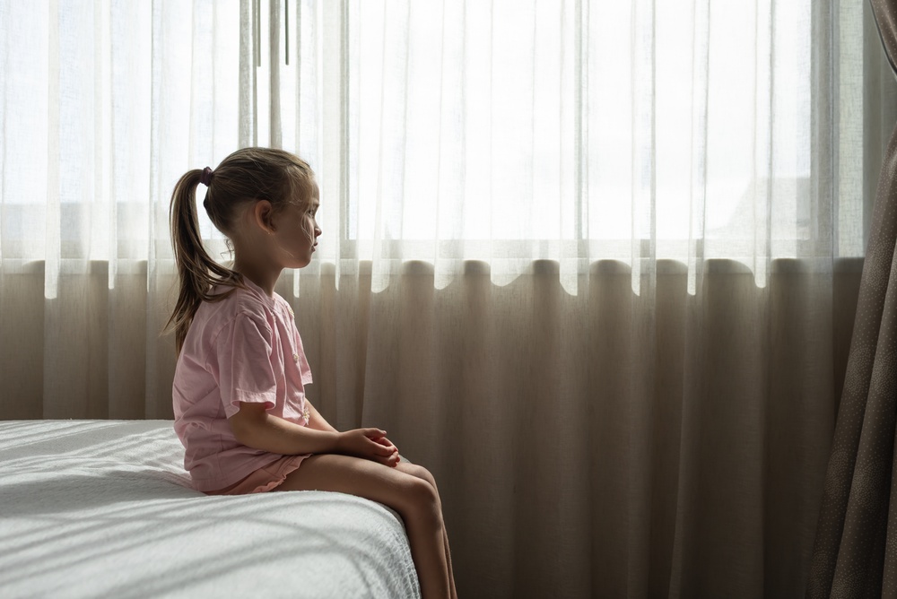 Sad Child Sitting Alone by Window – Mental Health, Anxiety and Loneliness in Childhood