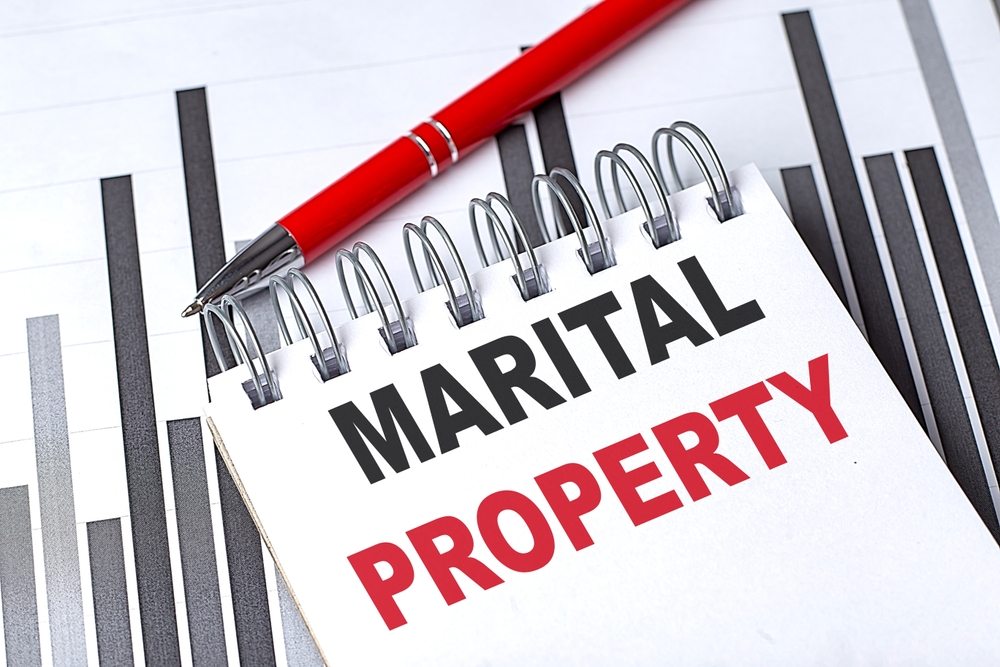 MARITAL PROPERTY text on a notebook on chart with pen.