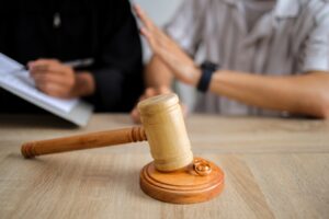 Wedding Rings and Judge Gavel on Table in Lawyer's Office. Divorce Concept.