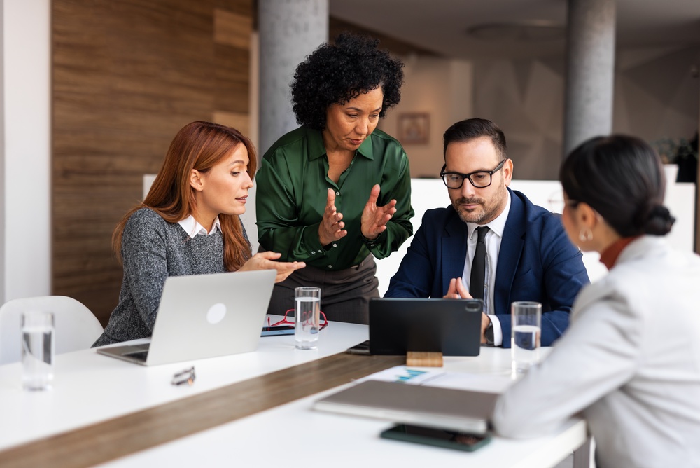 Group of businesspeople having a productive meeting, showcasing teamwork and collaboration in a modern office environment.