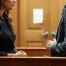 A woman and her attorney speaking privately in a quiet, professional atmosphere.